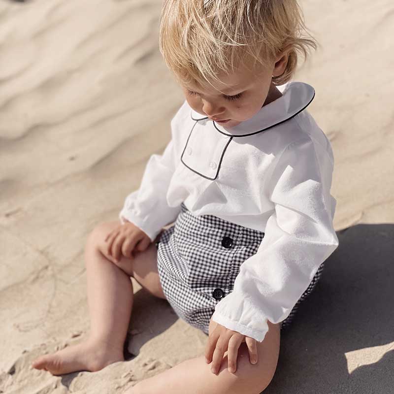 A sophisticated piped blouse in crisp white, showcasing meticulous tailoring and elegant design. This versatile garment effortlessly combines professionalism with a touch of modern flair, perfect for any fashion-forward wardrobe.