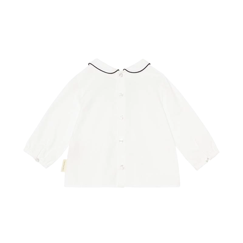 A sophisticated piped blouse in crisp white, showcasing meticulous tailoring and elegant design. This versatile garment effortlessly combines professionalism with a touch of modern flair, perfect for any fashion-forward wardrobe.
