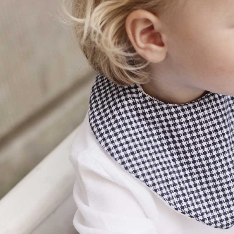 A sophisticated image featuring "The Vichy Neck Scarf," a stylish accessory adorned with a timeless checked pattern. This versatile scarf adds a touch of elegance to any outfit, making it a chic and classic addition to your accessory collection.